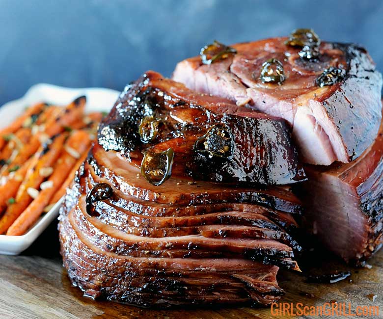 spiral sliced ham on wood platter with carrots to left