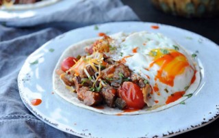 white plate with tortilla, beef, salsa and egg