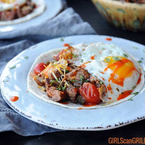 white plate with tortilla, beef, salsa and egg