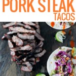 slate platter of sliced pork steak and tacos with purple cabbage