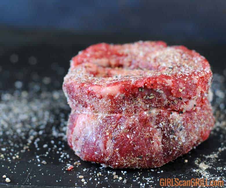 salt and pepper on spinalis steak with gray background