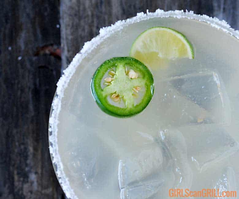 close up top view of smoked jalapeno margarita with lime and jalapeno