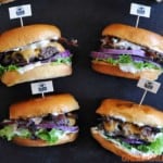 4 hamburgers on slate with lettuce, cheese and mayo
