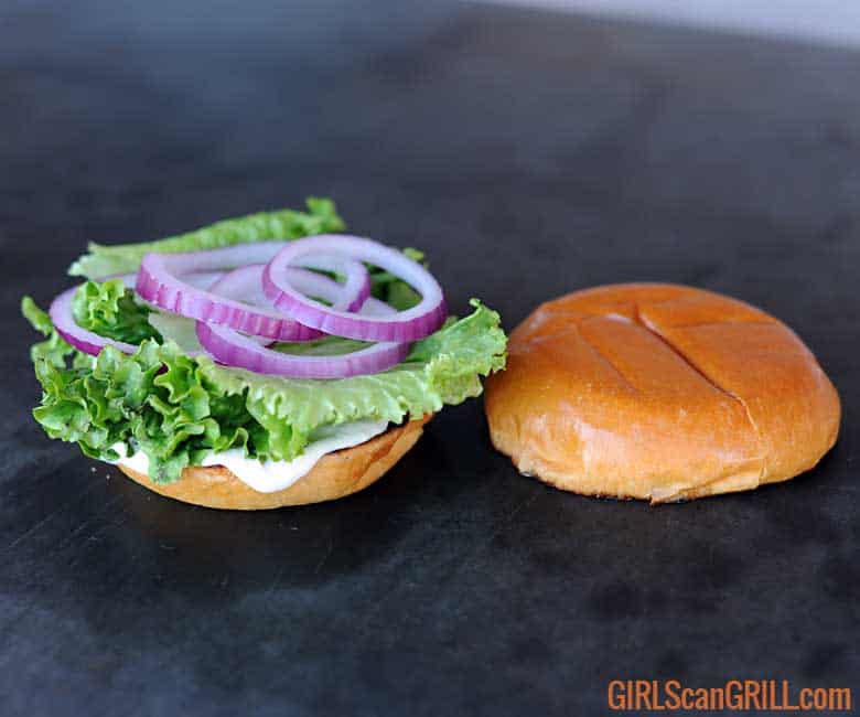 top bun to right, bottom bun to left with mayo, lettuce, red onion