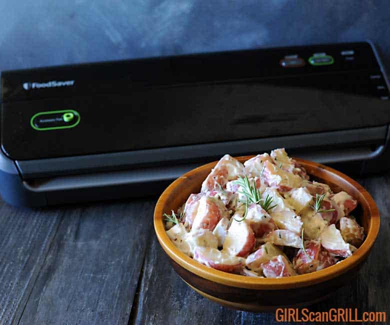 bowl of potato salad on gray background with Foodsaver in background