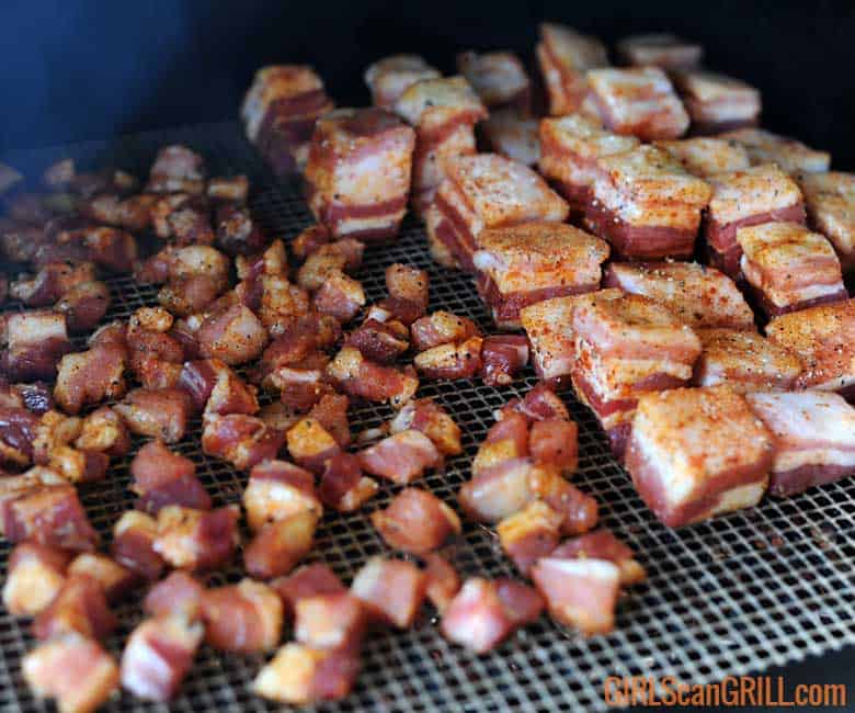 small cubes of pork belly on grill next to larger cubes