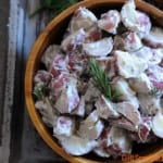 wooden bowl of potato salad on gray background