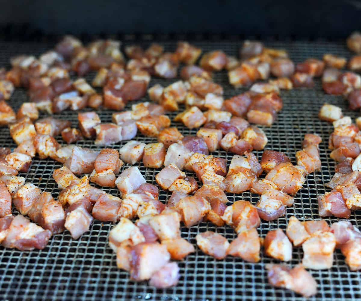 small cubes of pork belly on smoker.