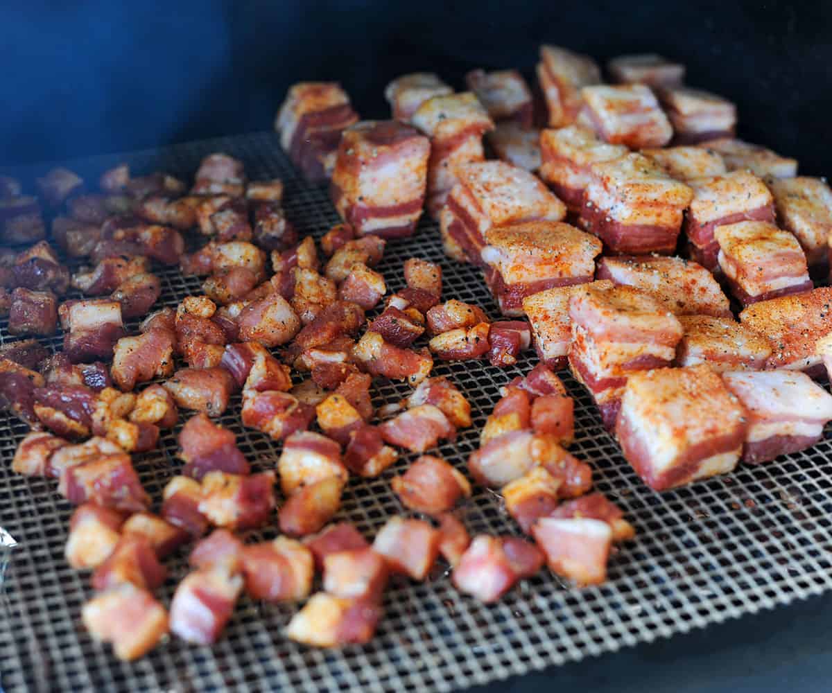small and large pork belly cubes on smoker.