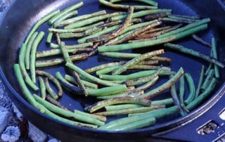 garlic green beans sauteeing in cast iron skillet