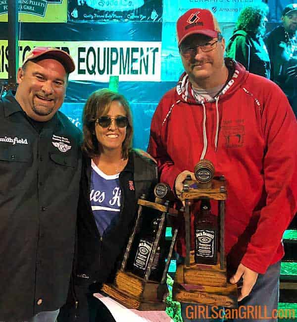 two men and a woman hold trophies
