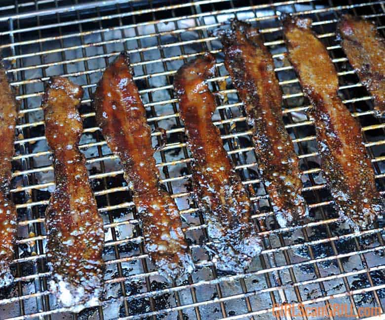 brown sugar bacon cooking on rack in smoker