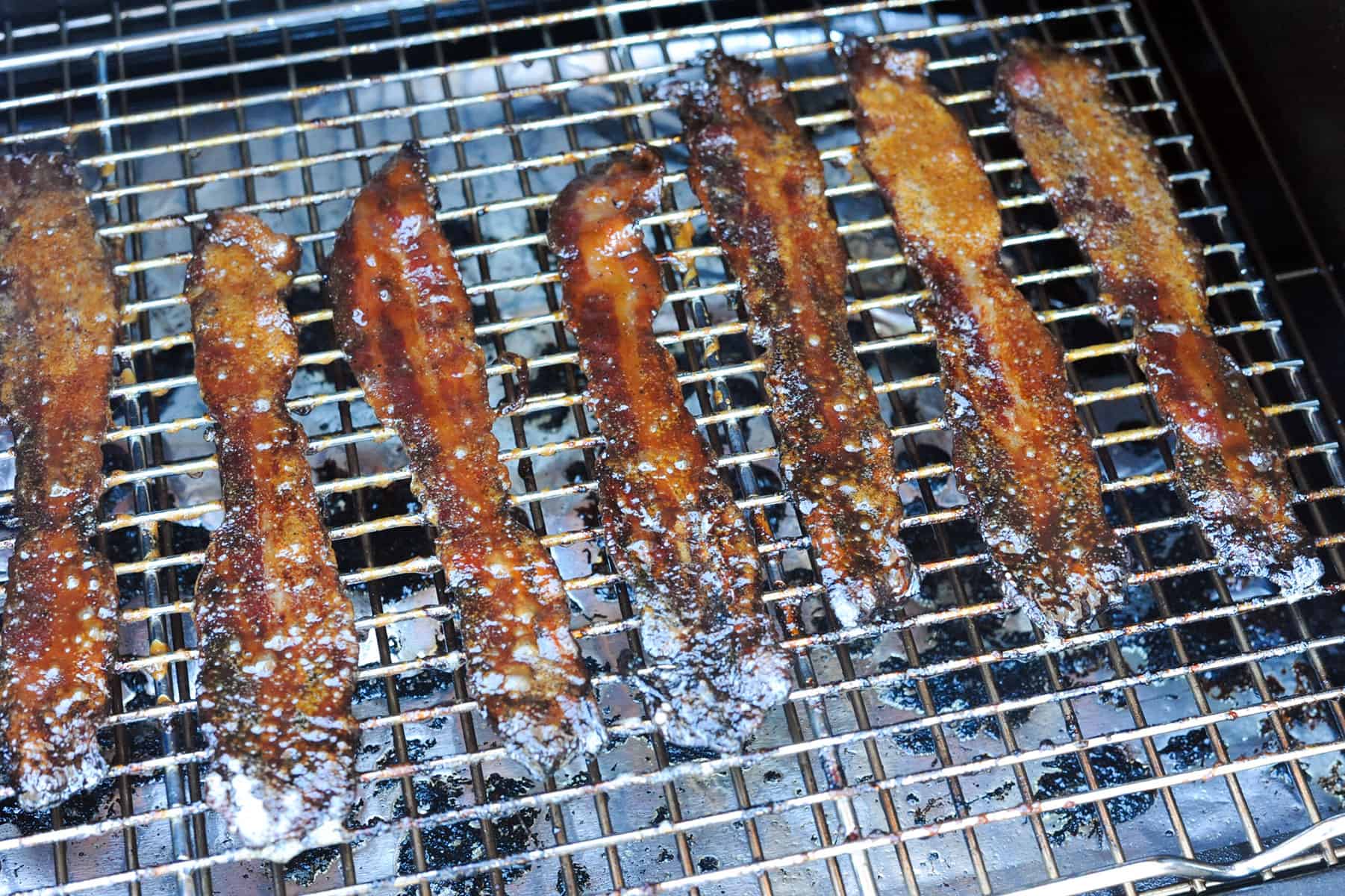 brown sugar bacon crisping on grill.