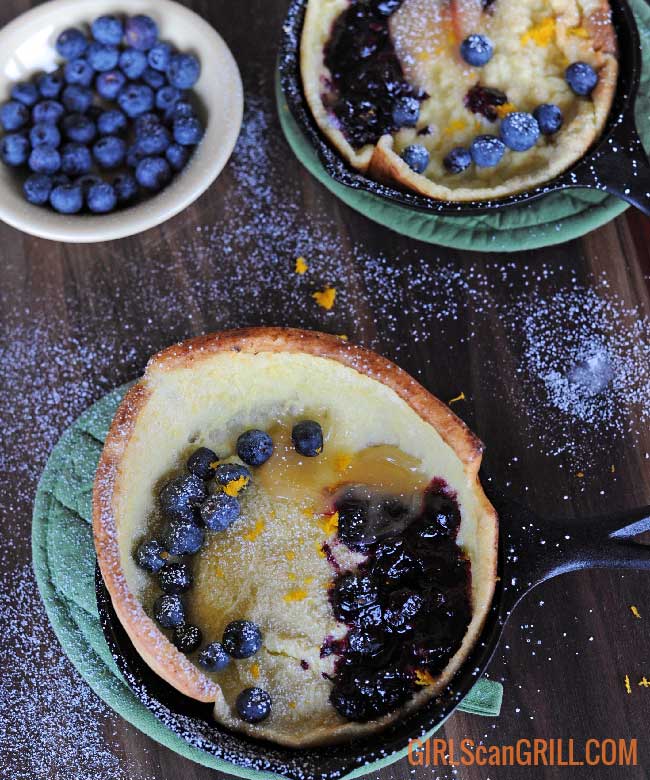 two dutch baby pancake skillets near bowl of blueberries