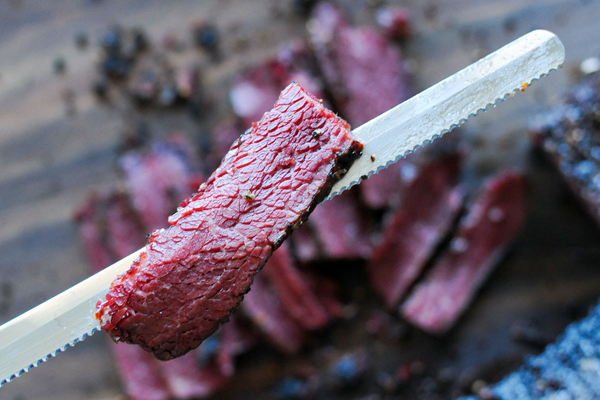 slice of chuck roast pastrami laying on knife.