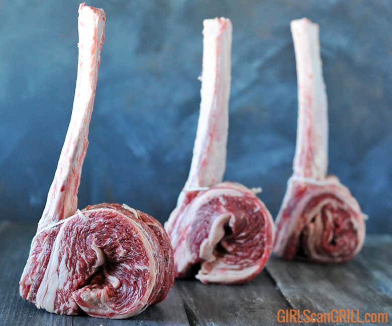three tomahawk short ribs standing up with gray background