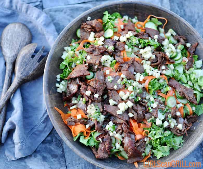 large bowl of beef bulgogi salad with peeled carrots and beef