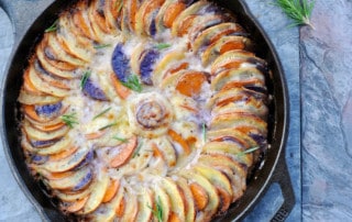 tri-color sweet potatoes spiraled in cast iron with baked cream sauce