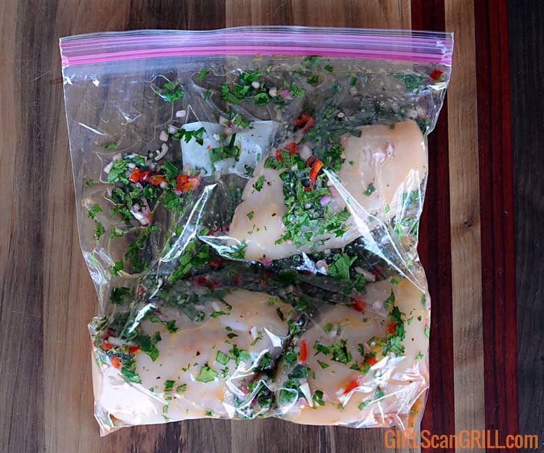 zip-top bag filled with three chicken breasts and marinade