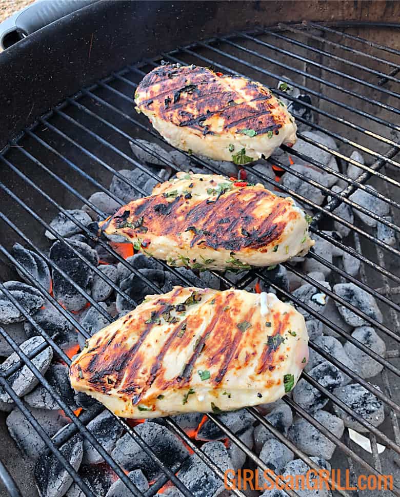 three chicken breasts on grill with grill marks