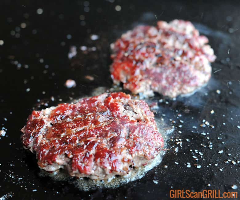 two smoked beef patties, charred and mahogany in color