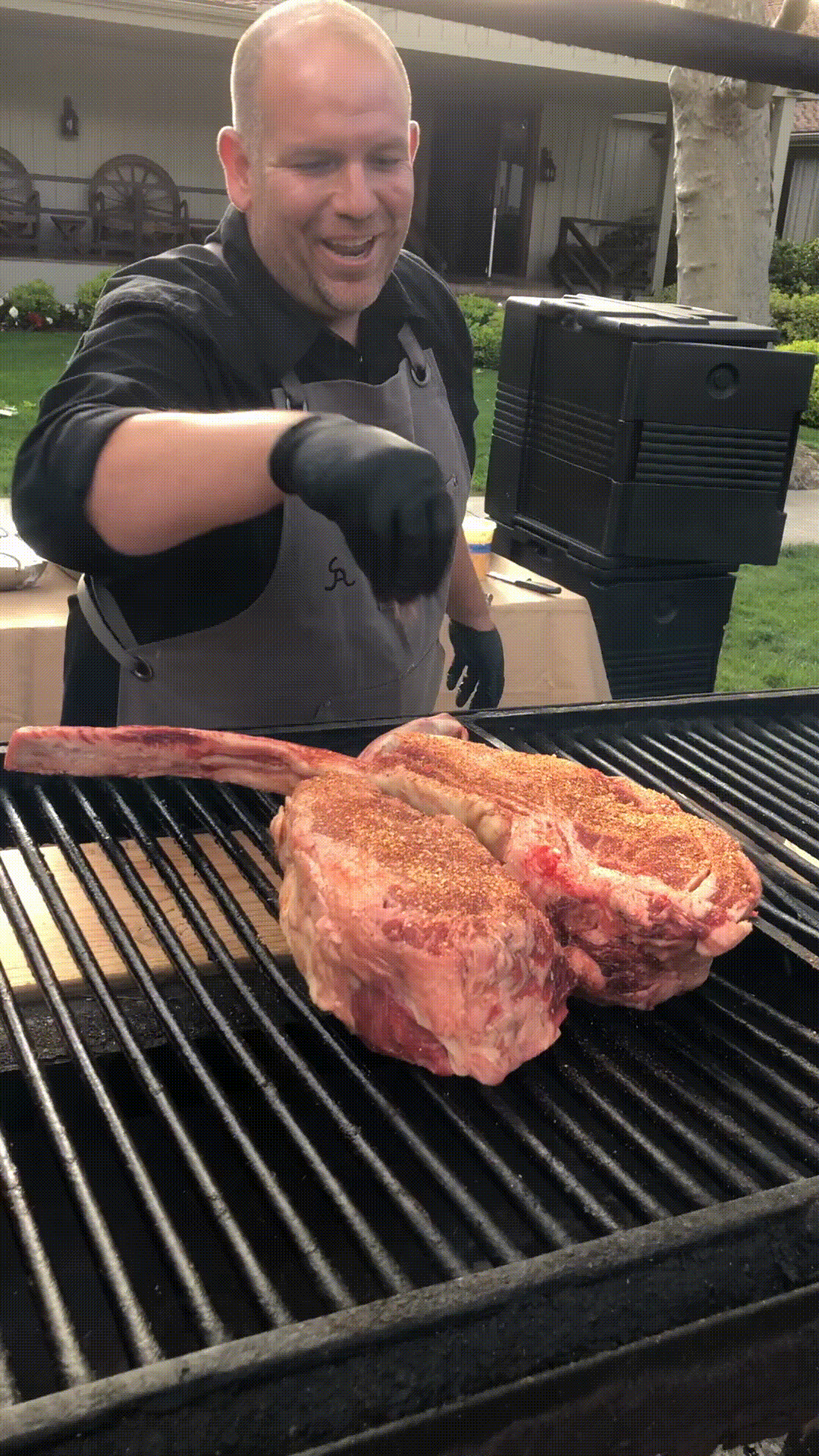 chef sprinkling salt on tomahawk steaks on grill