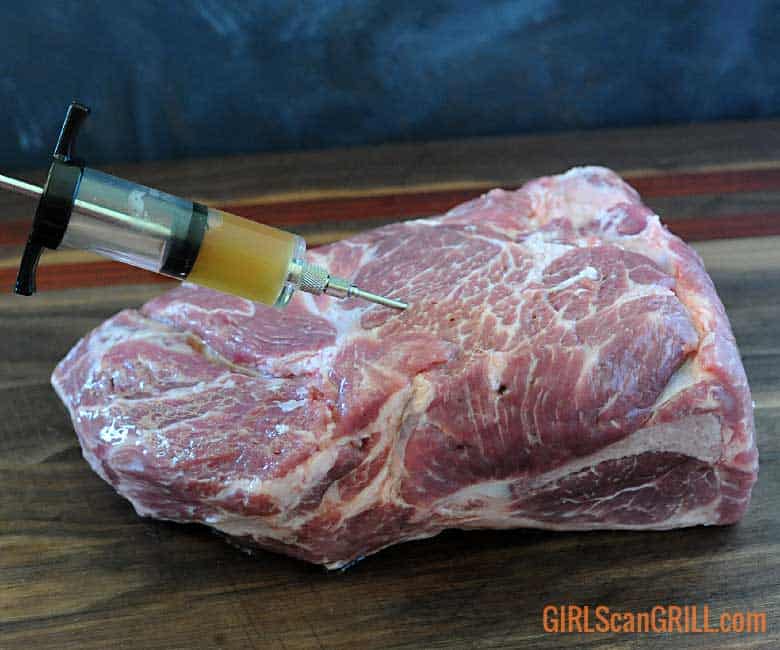 needle injecting juice into a pork butt.