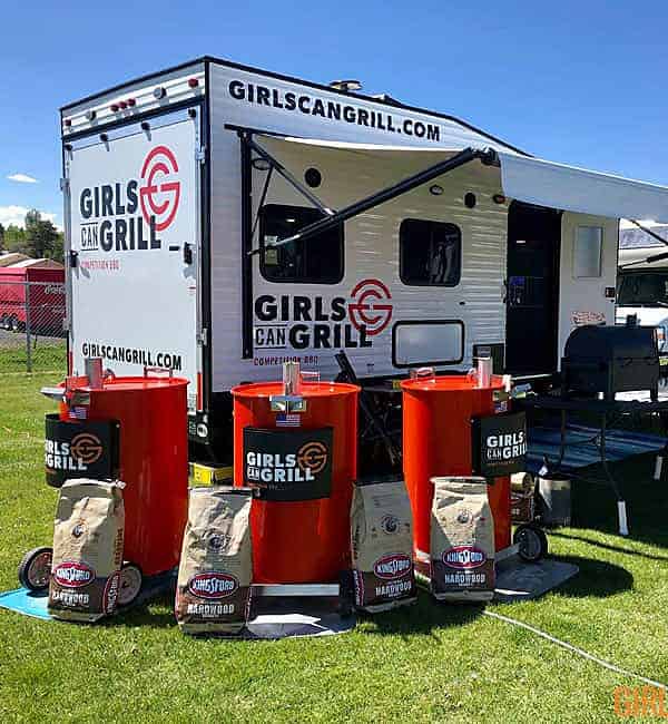 trailer with three orange drum barrels in front with girls can grill logo