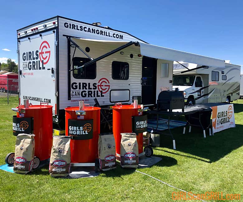 trailer with three orange drum barrels in front with girls can grill logo