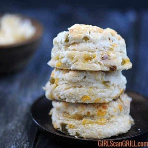 three hatch cheddar biscuits stacked on wooden plate