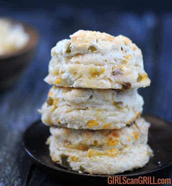 three hatch cheddar biscuits stacked on wooden plate