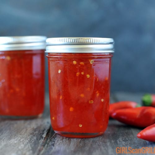 two jars full of bright red pepper jelly