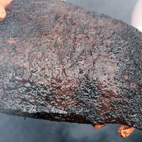 holding a cooked brisket flat