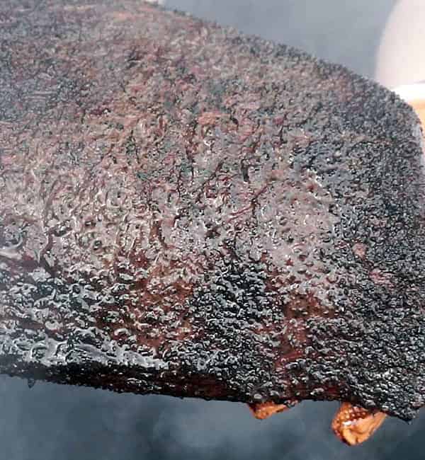 holding a cooked brisket flat