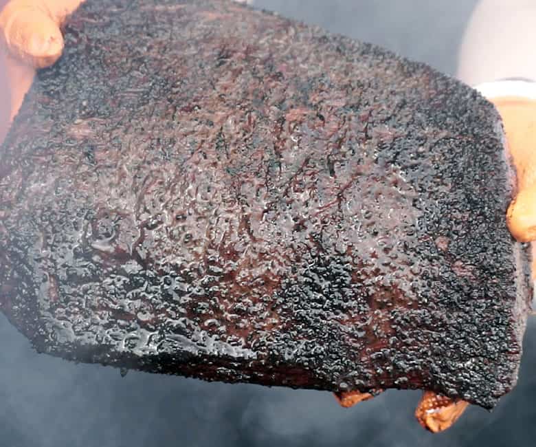 holding a cooked brisket flat