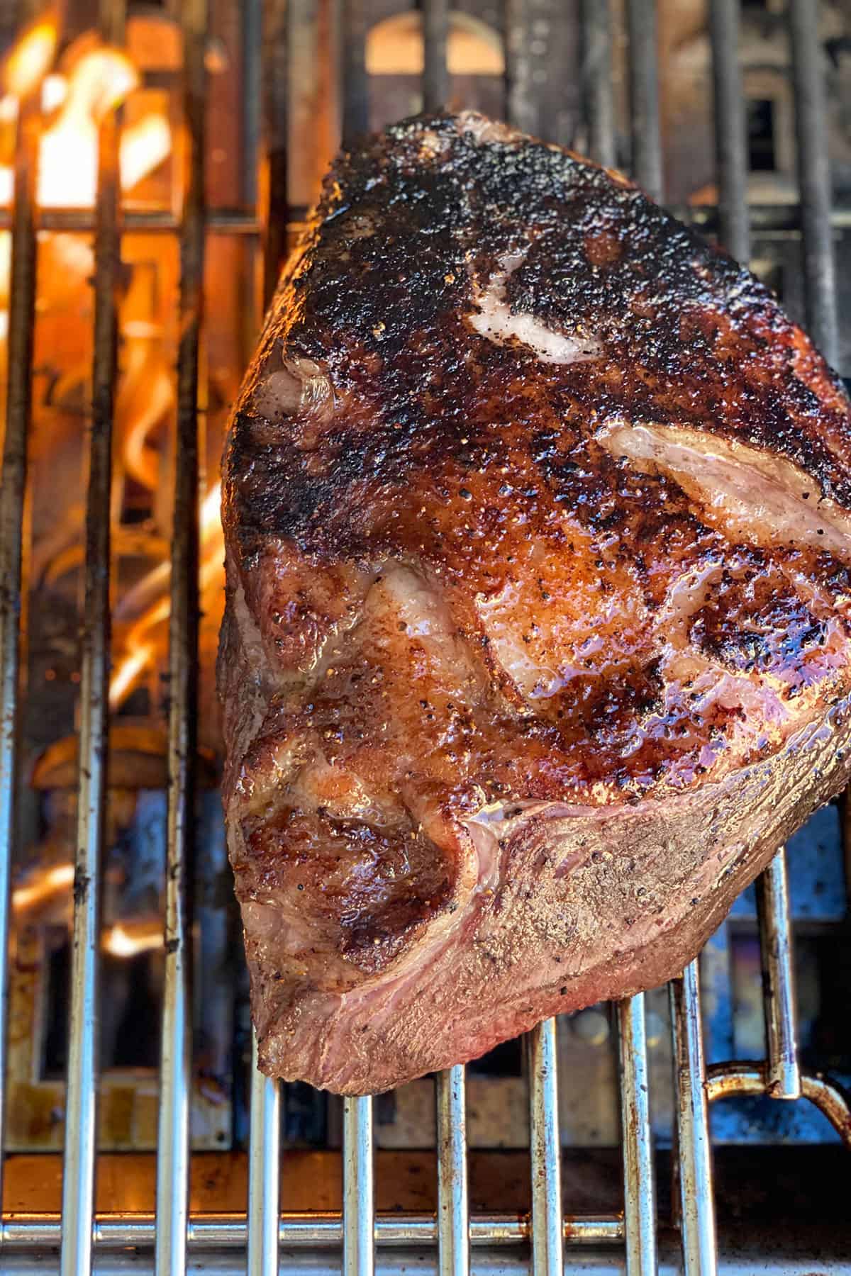 Searing whole picanha steak on grill. 
