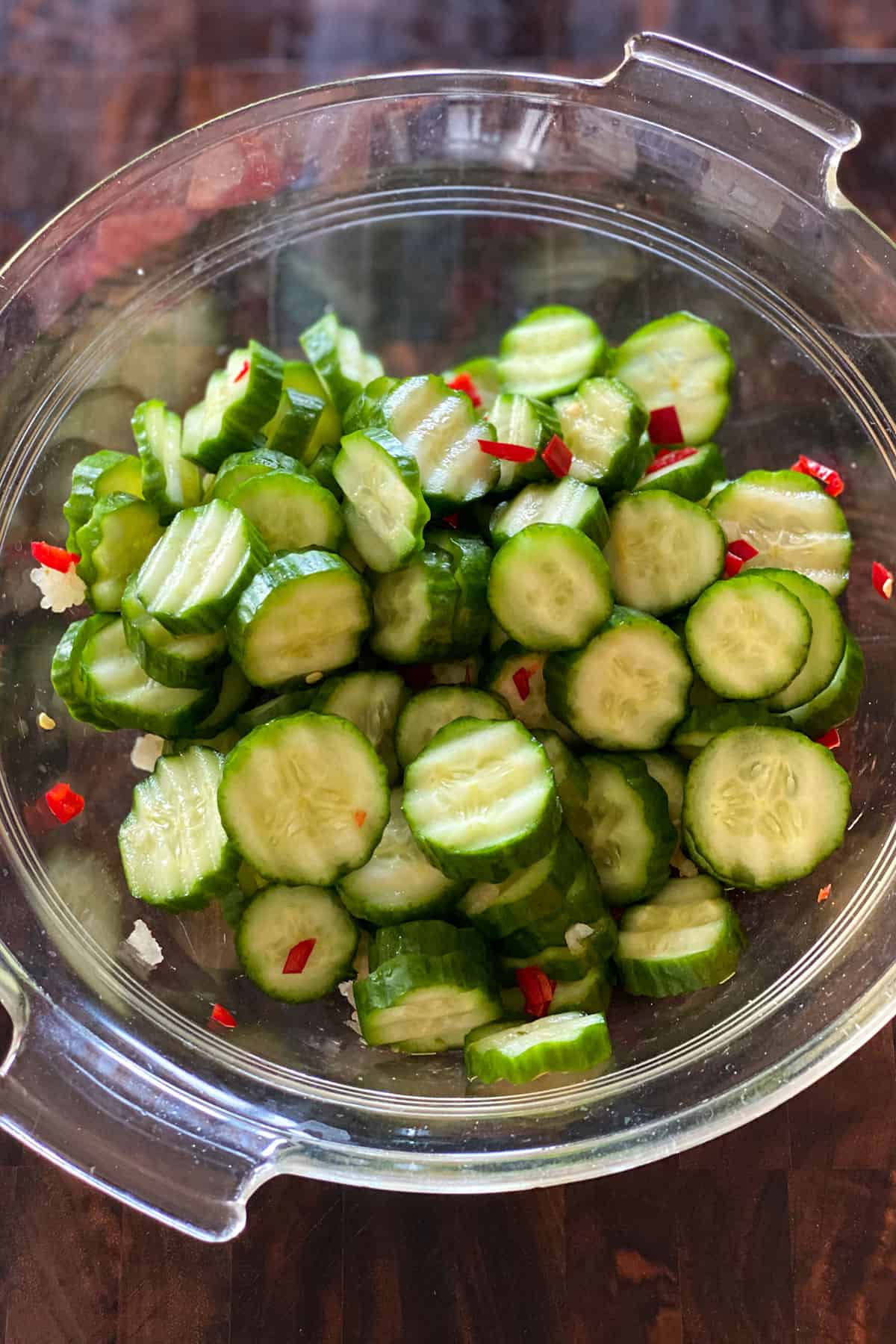bowl of sliced cucumbers, fresno peppers and garlic.