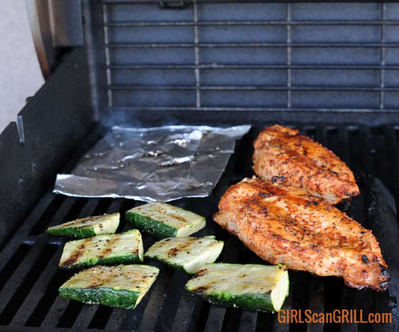 foil pouch on grill with chicken and veggies.