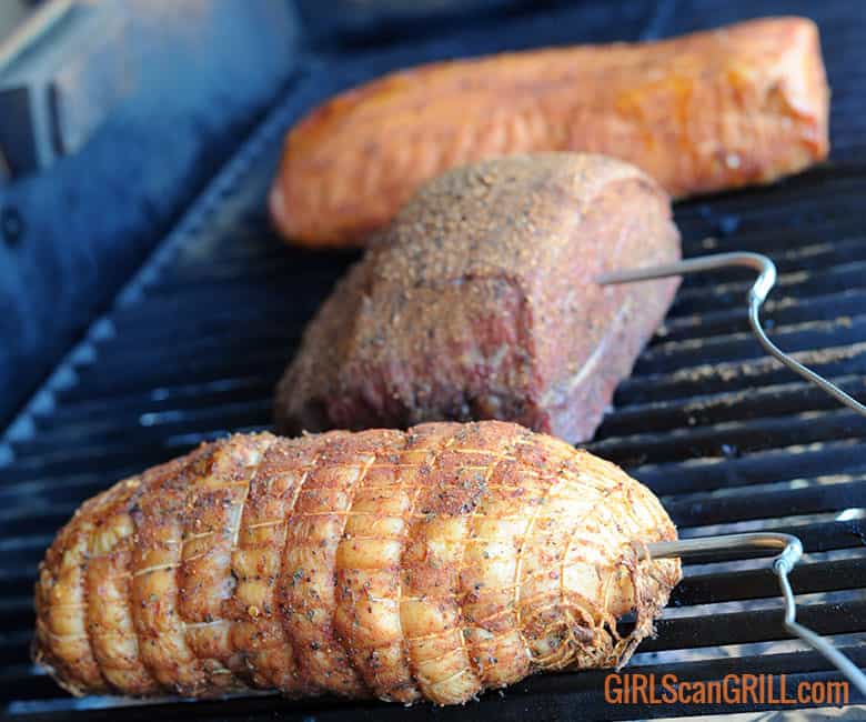 three pieces of meat on grill smoking