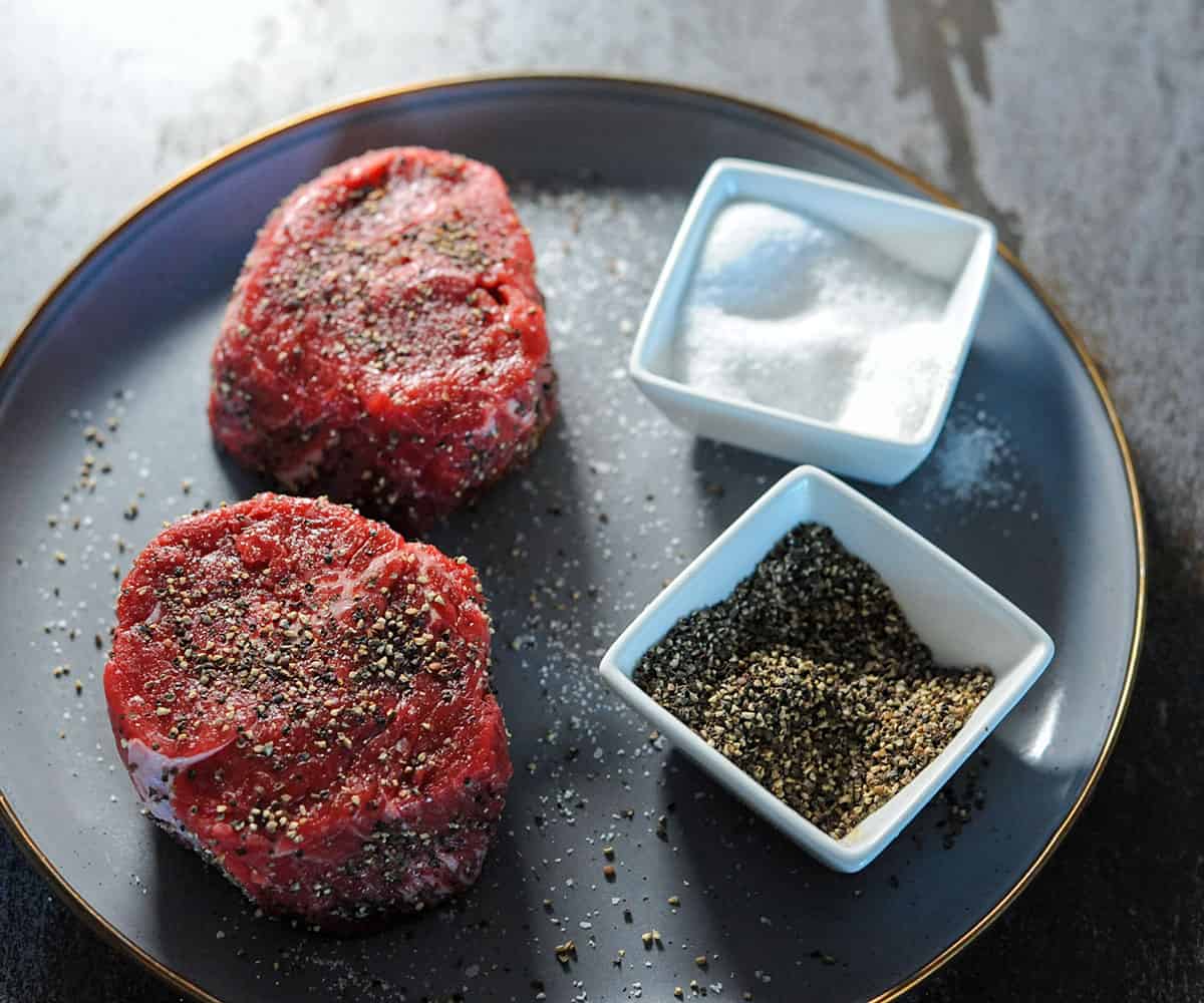2 filet mignon steaks seasoned with salt and pepper.