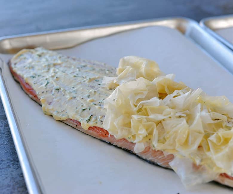 phyllo dough crumpled ad set on half of a salmon filet.