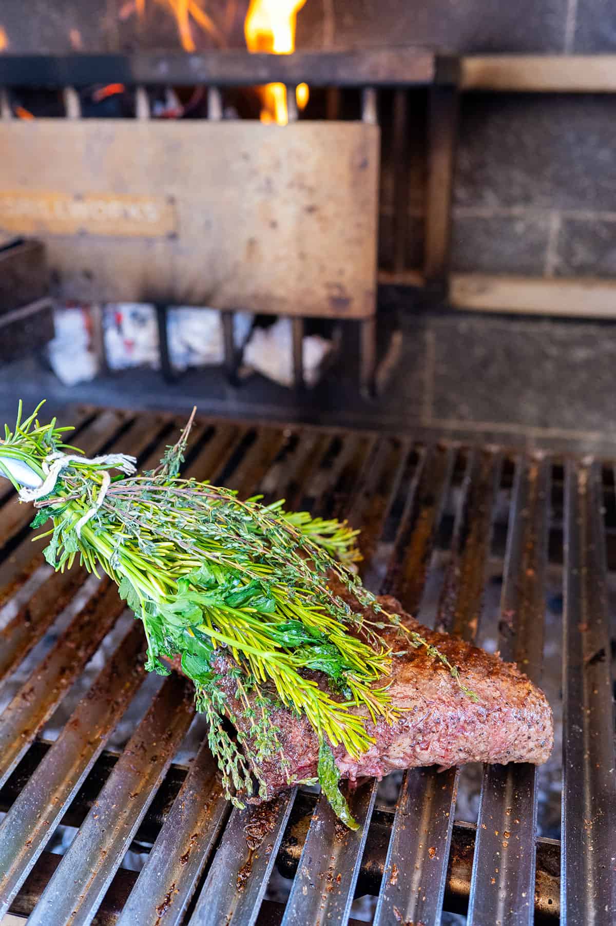 Basting tri tip with an herb brush.