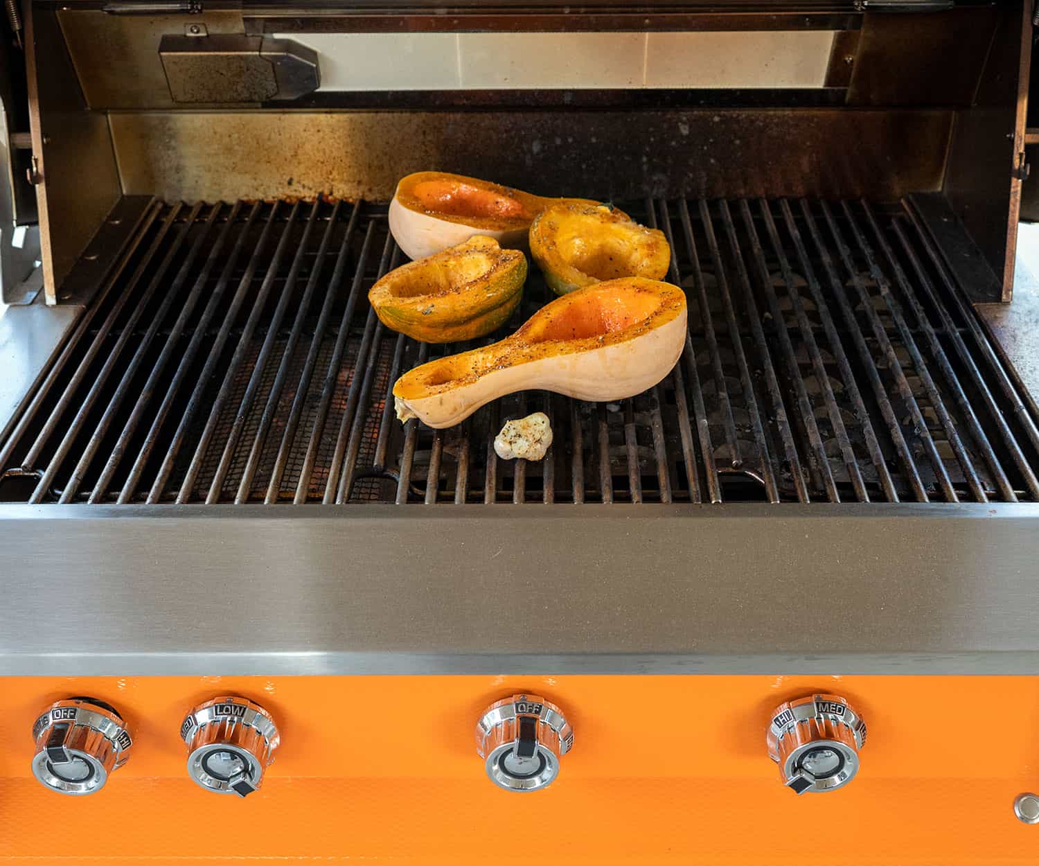 butternut and acorn squash halves on grill