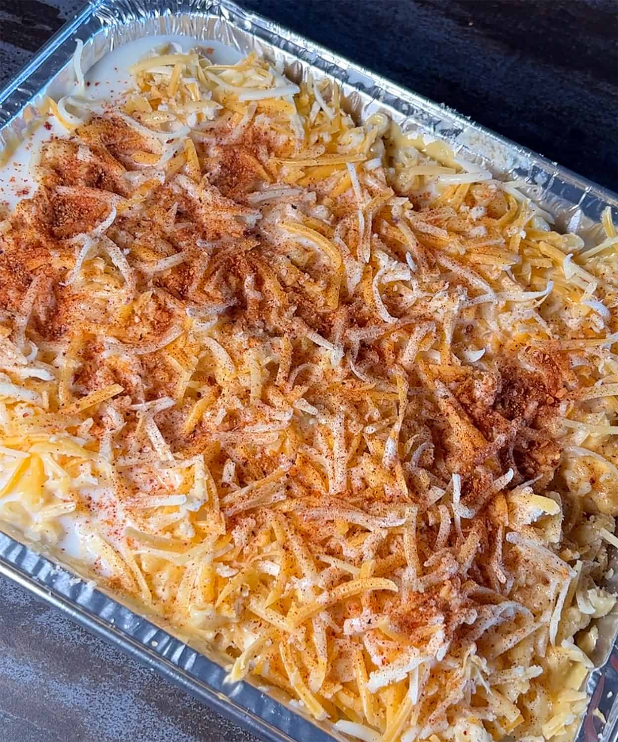 macaroni in pan topped with cheese and rub