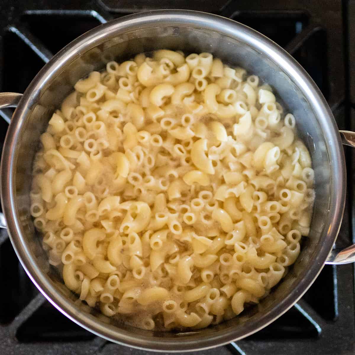 macaroni noodles boiling in pot on stove.