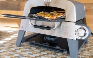 Cuisinart 3-in-1 Pizza Oven Plus with pizza coming out front door on peel