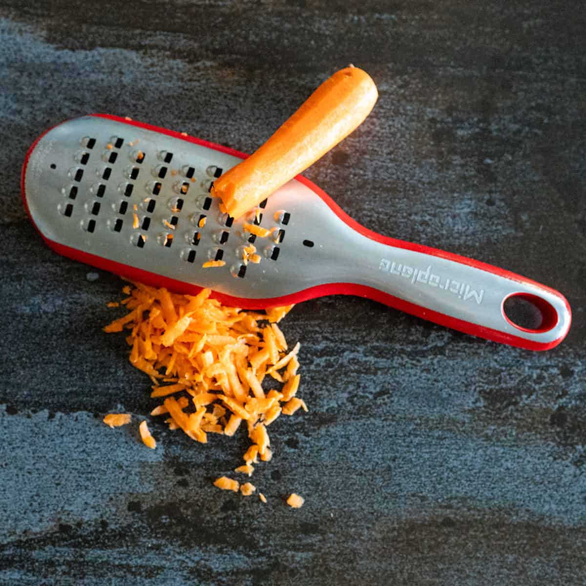 grating carrots with a cheese grater.