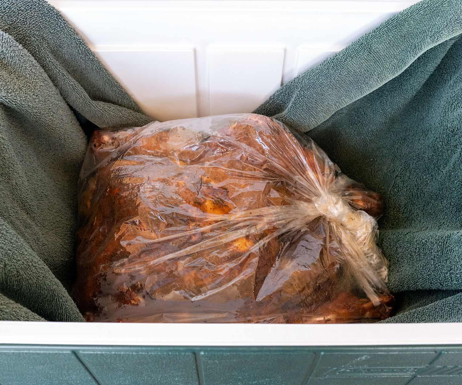 smoked turkey in bag in towel in cooler