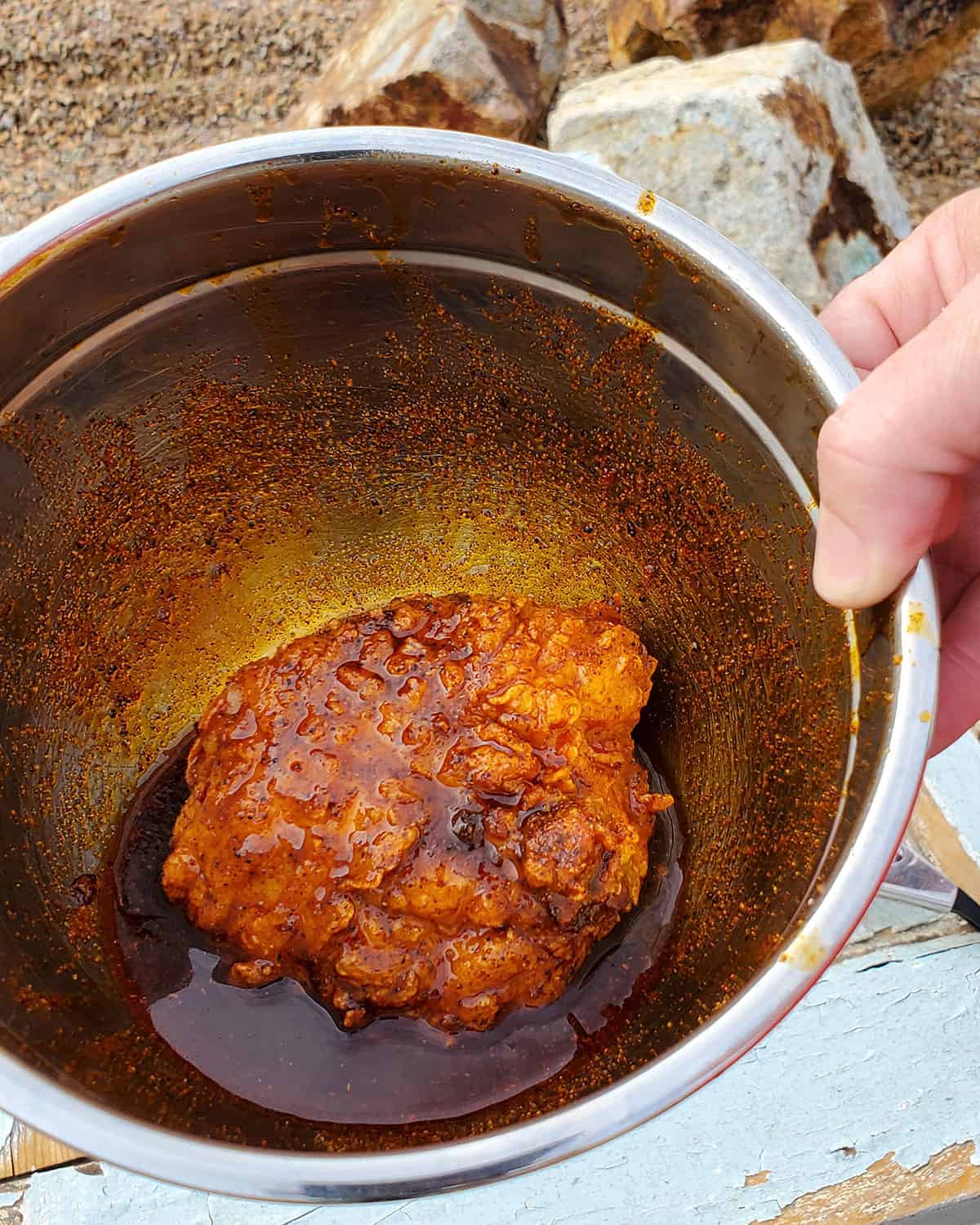 Fried chicken in bowl of Nashville hot sauce.