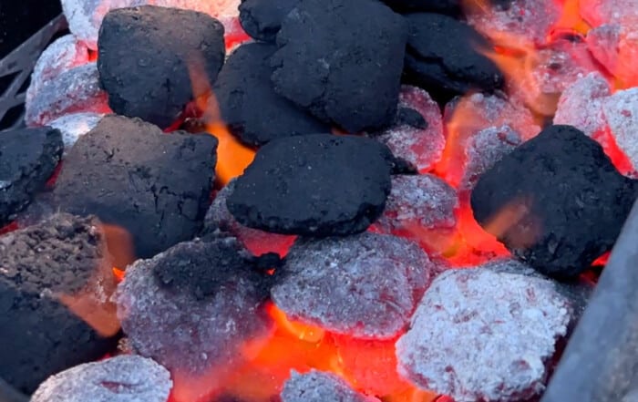 charcoal briquets burning in grill.